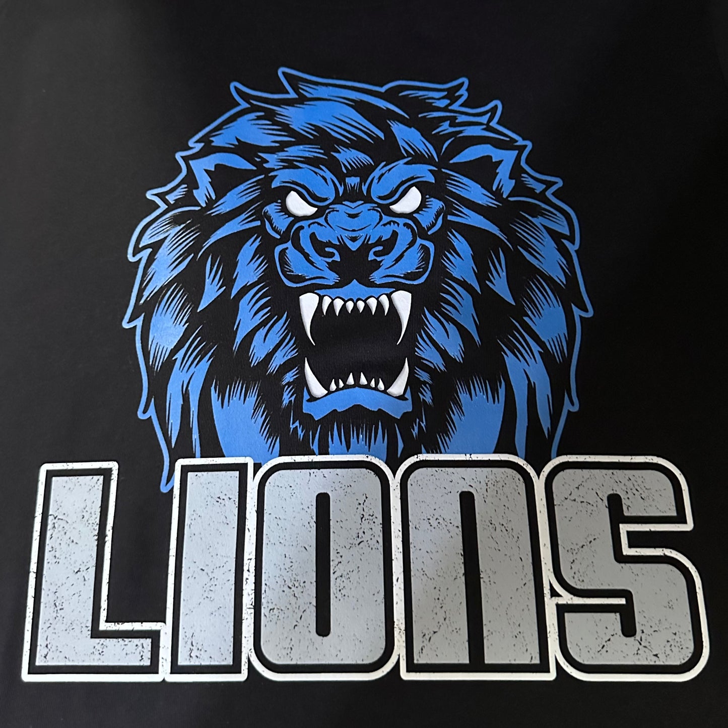 close up view of the restore the roar lions shirt on a black Bella canvas shirt